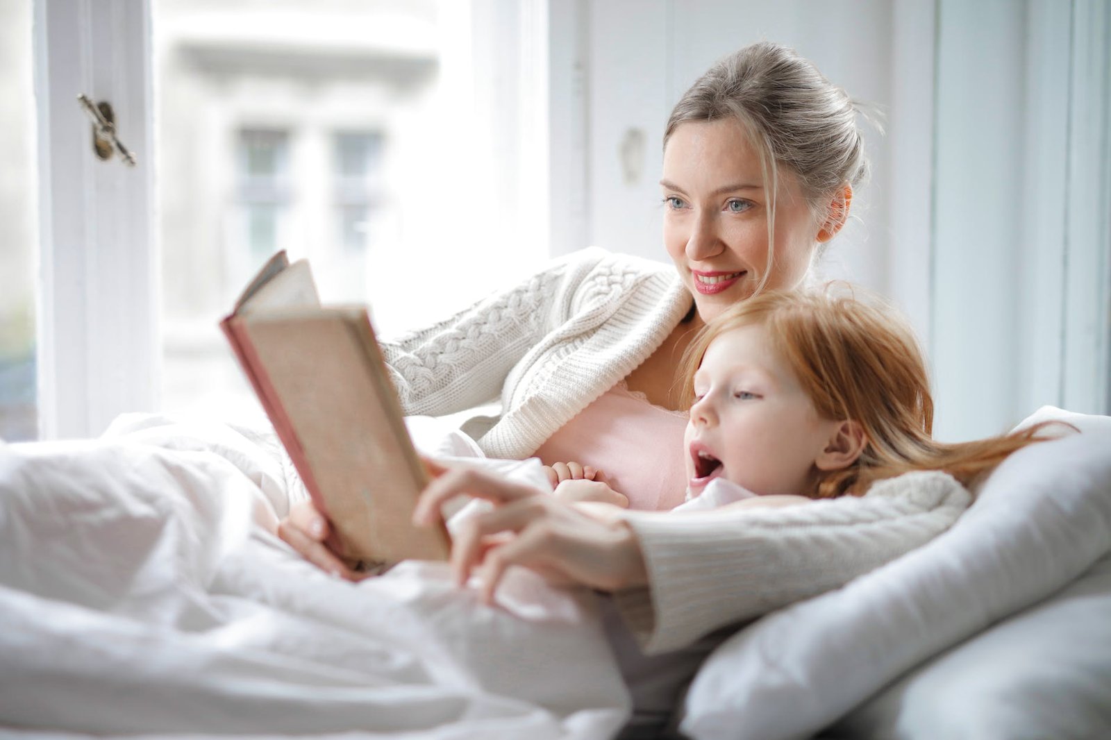 mother and daughter reading book with interest in bed -radical acceptance