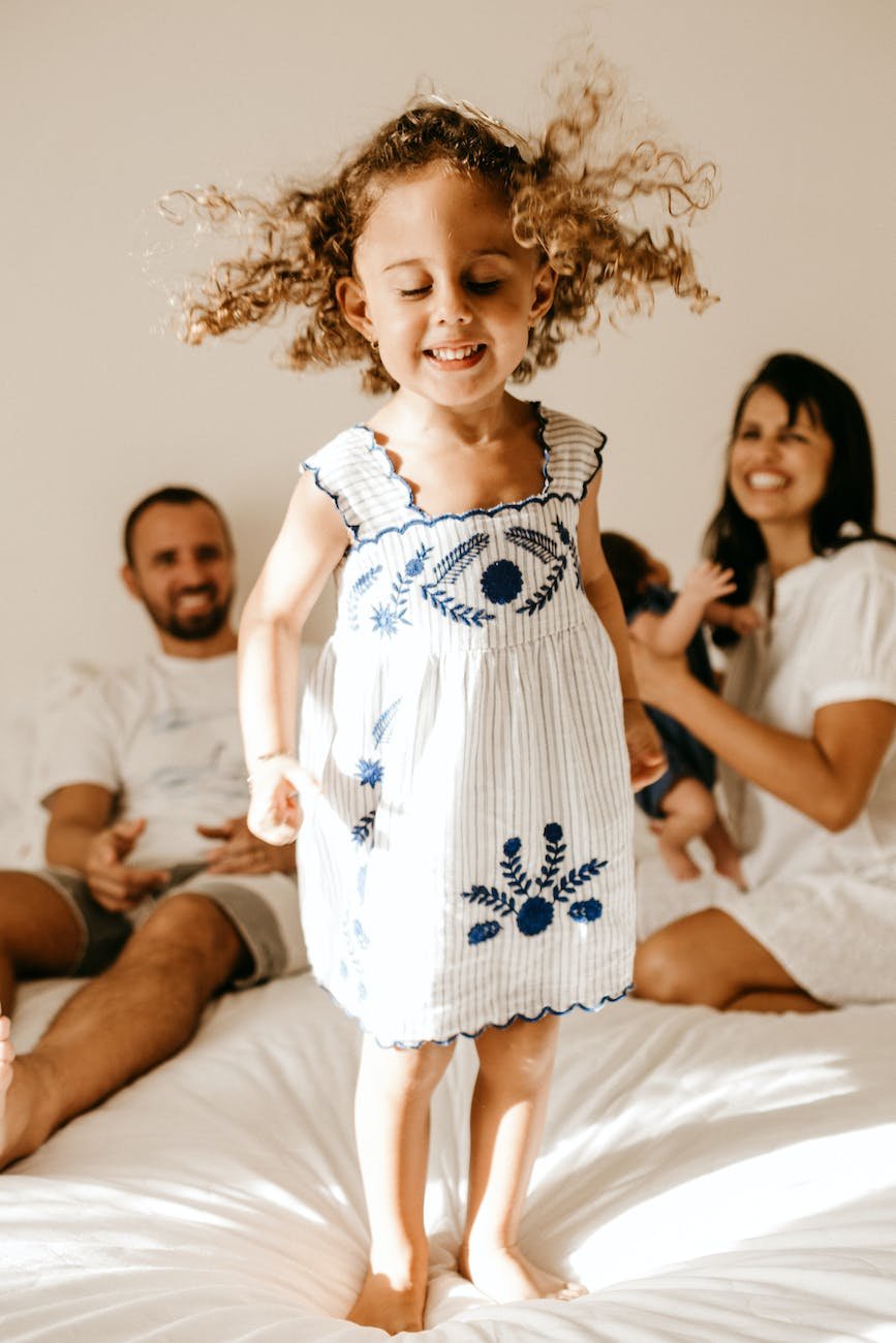 happy little kid having fun on bed with cheerful parents Autistic and ADHD Girls In Early Childhood