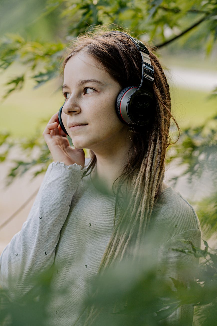 woman in gray sweater wearing black headphones
