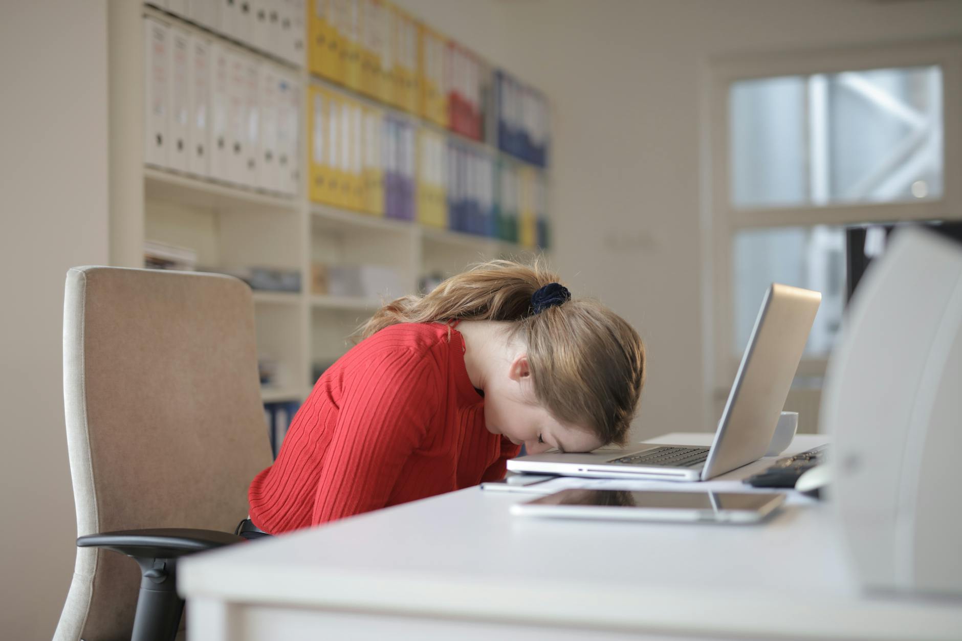 woman sitting on chair while leaning on laptop - self-care for mothers of neurodivergent children