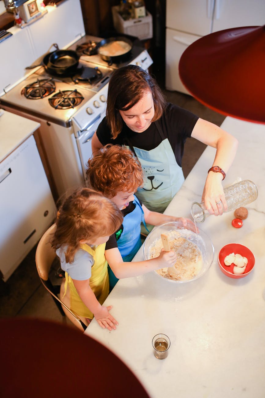 top view of a mom baking with her kids in a kitchen - good parenting vs brave mothering