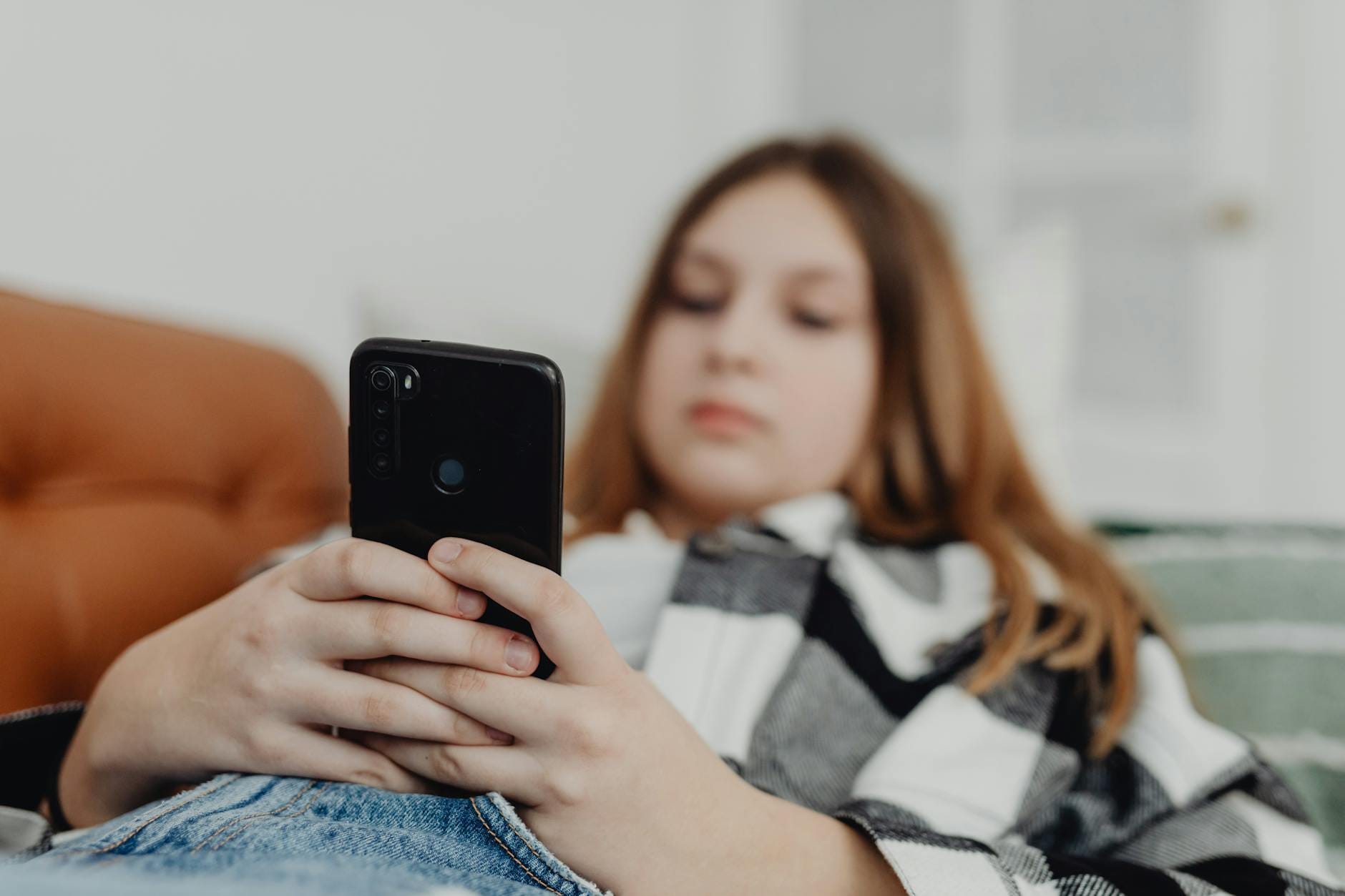 girl lying on sofa and using smartphone - Neurodivergent Mothers burnout isolation