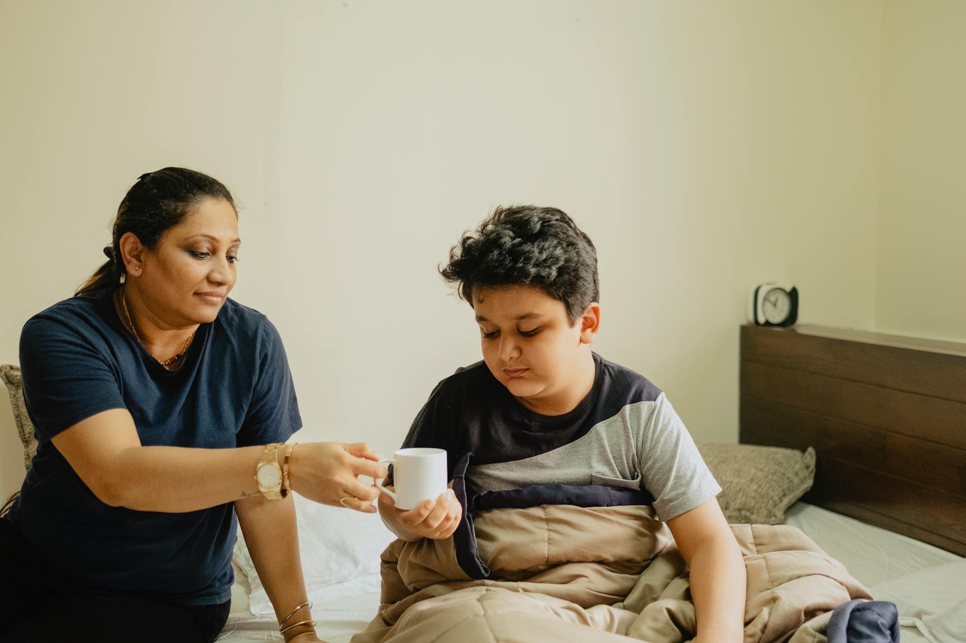 woman giving a boy drink on white mug - good parenting vs brave mothering