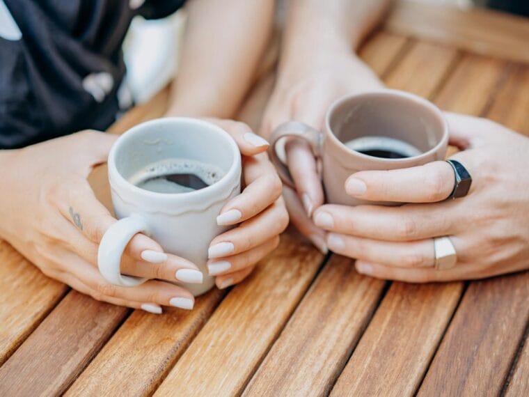 high angle view of two people drinking cups of coffee
