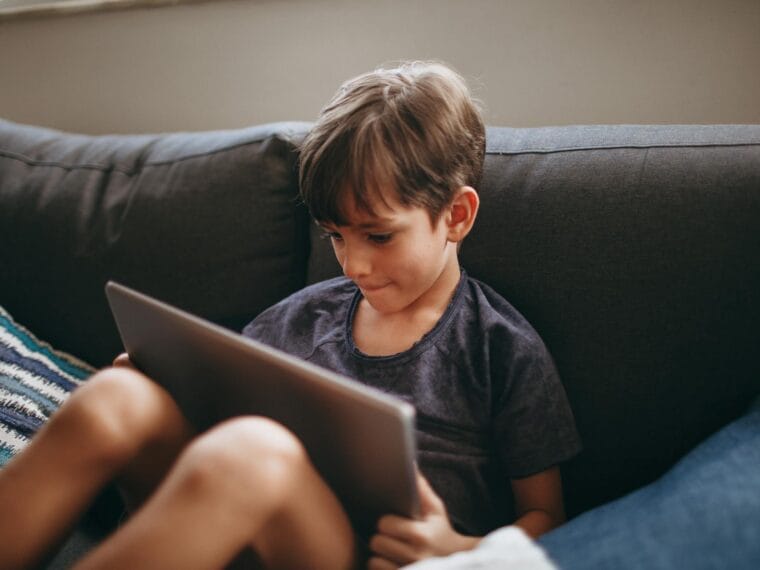 young boy engaging with tablet on cozy sofa Autistic Burnout Community for Parents