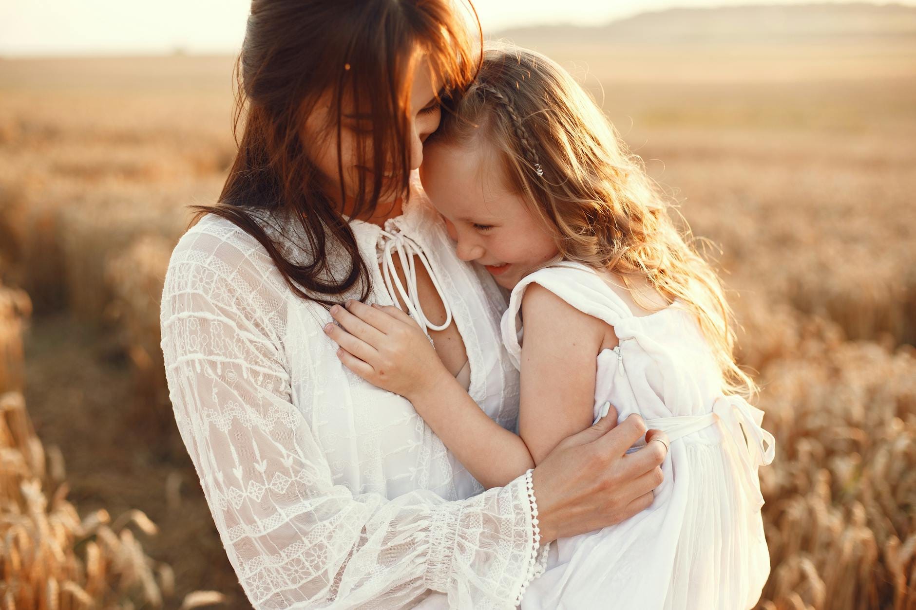 mother and daughter hugging on field - Neurodivergent masking