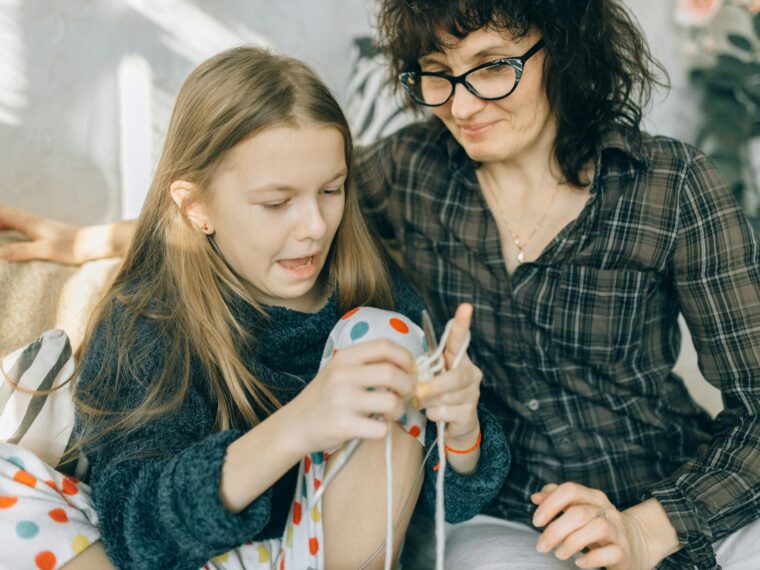 mother watching her daughter how to crochet