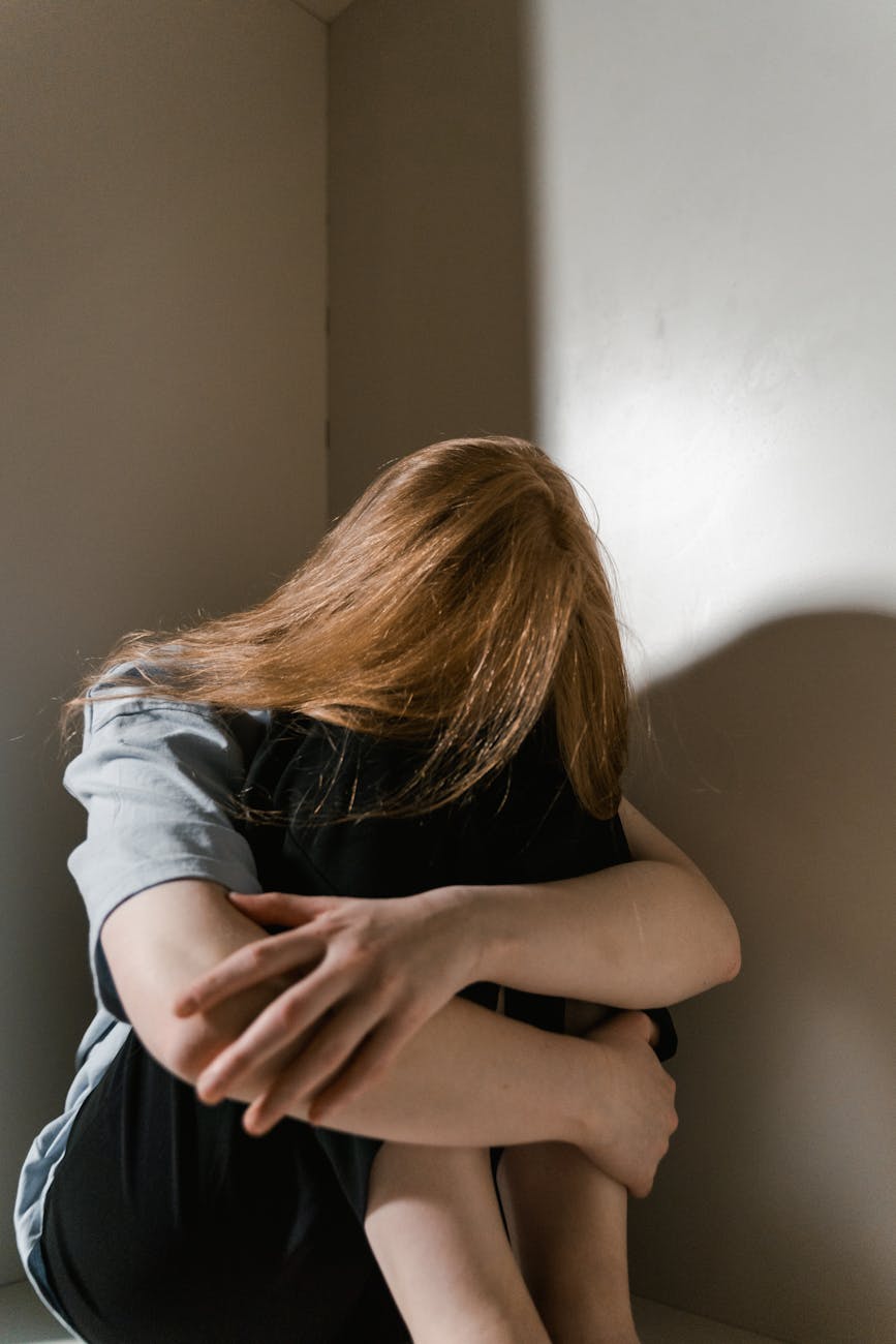 a lonely woman sitting by herself - Autistic Masking and Burnout 