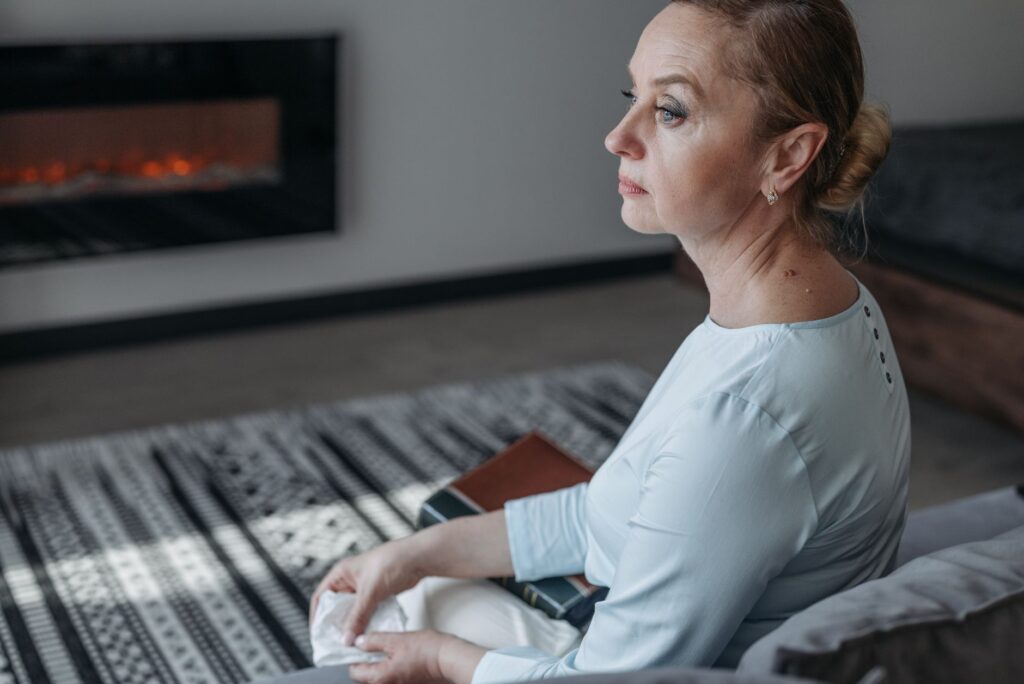 a woman in white long sleeve shirt sitting on the bench - Stabilising safety in autistic burnout recovery