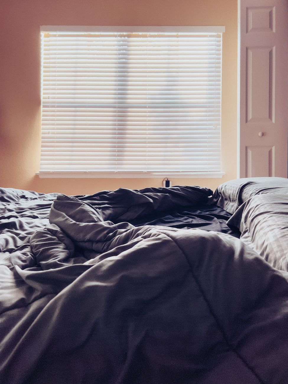 empty bed with sheets in home bedroom - low demand parenting for neurodivergent child in burnout