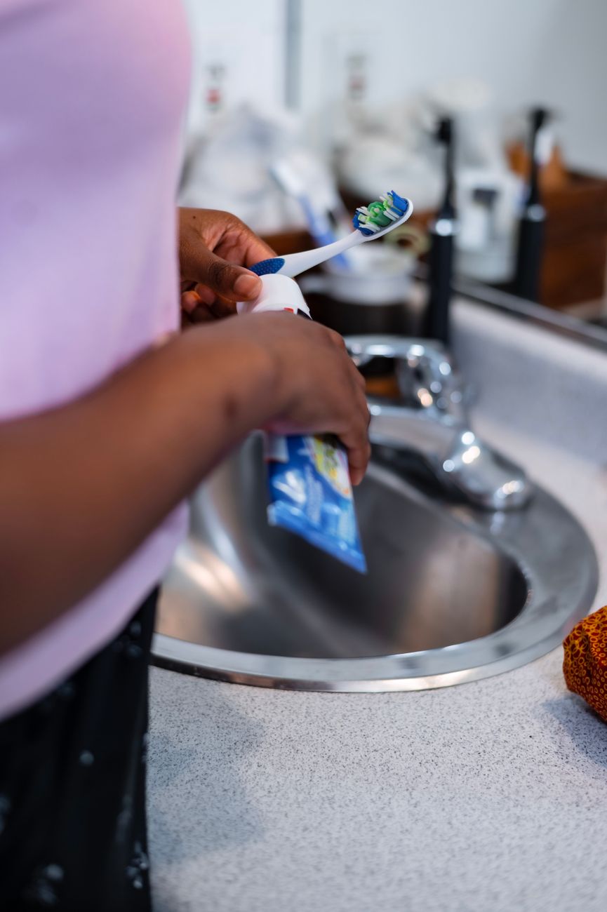 person holding blue and white toothbrush - low demand parenting for neurodivergent child in burnout